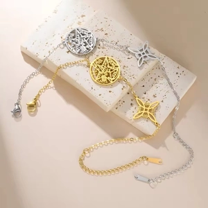 Detail of gold and silver stainless steel bracelets with pentagram and witch knot charms