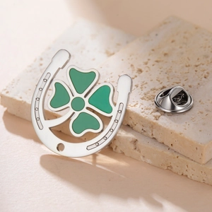 Detail of horseshoe four-leaf clover lapel pin with green enamel and butterfly clutch