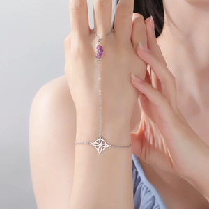 Detail of silver finger bracelet with purple amethyst stones and Celtic knot charm