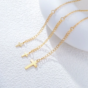 Three gold stainless steel necklaces with Virgin Mary cross pendants on a white surface