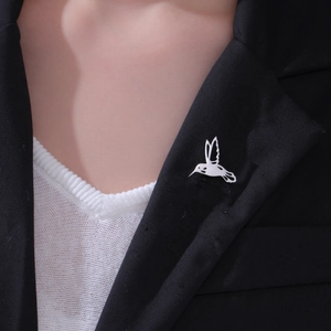 Elegant hummingbird brooch in silver stainless steel pinned to a black suit lapel