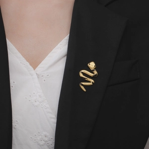 Chic gold-plated snake brooch with black texture pinned on a formal suit lapel