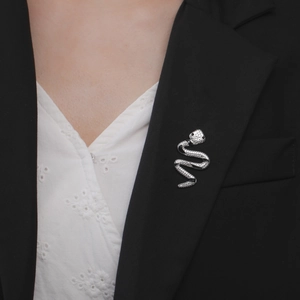 Chic silver snake-shaped stainless steel brooch with black stone eyes on a black suit lapel