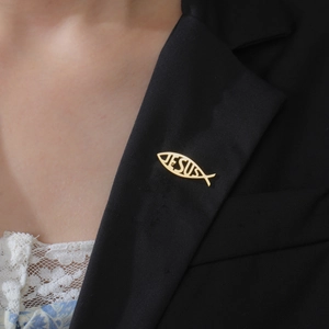 Broche poisson Jésus en acier doré fixée sur le revers d'un costume noir pour homme et femme