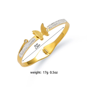 Close-up of golden butterfly bangle with zircon stones and frosted texture finish
