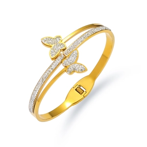 Detailed macro view of gold butterfly bangle featuring micro-pave crystals and spring hinge