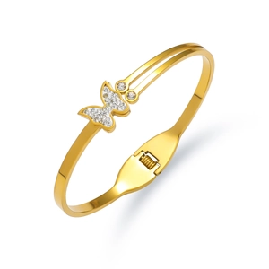 Detailed view of golden butterfly bangle with sparkling zircon pavé and hinge closure