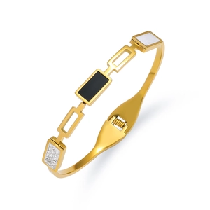 Detailopname van gouden armband met zwart-witte inleg en pavé-gezette zirkoonsteen