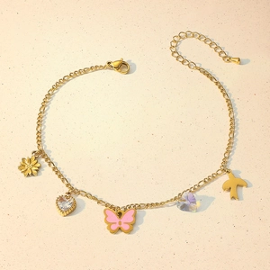 Gold anklet with sunflower, heart, and butterfly charms on a minimalist figaro chain