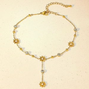 Close-up of golden anklet featuring daisy charms and sparkling zircon detailing