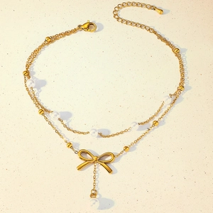 Close-up of golden double-layer anklet with pearl beads and elegant butterfly charm