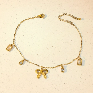 Detail of gold butterfly anklet with teardrop and rectangular zircon crystal charms