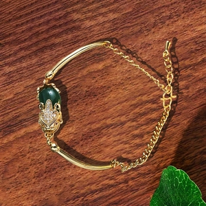 Detaillierte Makroansicht des retro vergoldeten Armbands mit Jade und Pixiu-Schnitzerei