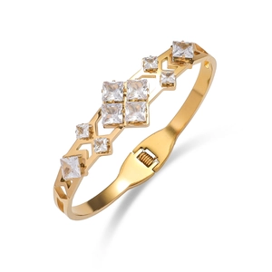 Gold-plated hollow bangle with square zircons and wavy geometric design on white backdrop