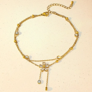 Macro detail of gold-plated double-layer anklet featuring zircon flower and teardrop charms