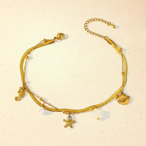 Detailed shot of gold layered anklet with seahorse starfish shell charms and zircons