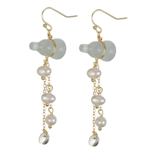 Macro view of gold-plated tassel earrings featuring green jade gourd and white pearls
