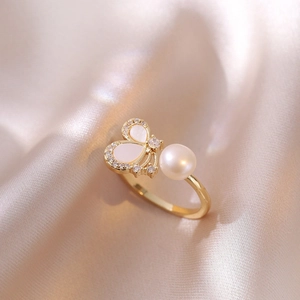 Macro di ali di farfalla in madreperla e perle su un anello dorato regolabile