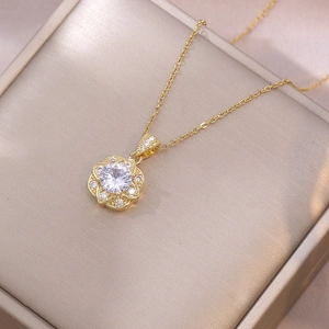 Elegante goldene Blumenhalskette mit Zirkonia-Steinen auf einer Champagner-Schmuckbox
