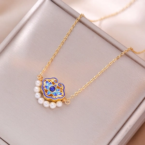 Macro-detail van de vintage gouden ketting met blauw emaille hanger en zoetwaterparels