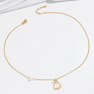 Detail van 18K gouden parelketting met peervormige hanger en glinsterende diamantaccenten