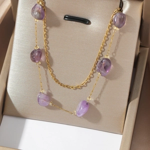 Golden titanium necklace with natural purple agate stone charms in a jewelry box