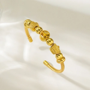 Bracelet jonc ouvert torsadé doré avec breloques couronne et perles polies pour femme