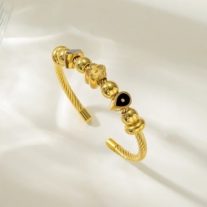 Vue détaillée du bracelet câble en acier doré avec breloques fleurs et perles