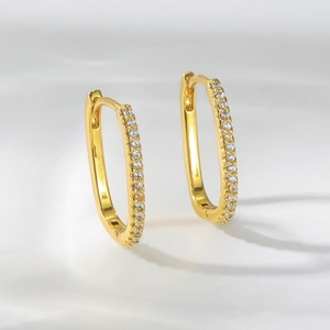 Detailansicht goldener ovaler Huggie-Ohrringe mit mikroverzierten weißen Zirkonias