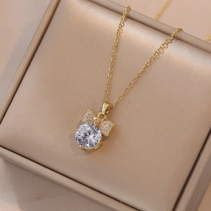Detail van gouden strikketting met een grote ronde zirkoon en sprankelende zetting