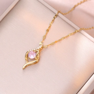Gouden klaver ketting met roze kristal en zirkoon aan een elegante golvende ketting