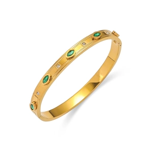 Bracelet en acier doré avec zircon vert marquise et cristaux blancs sur fond blanc épuré