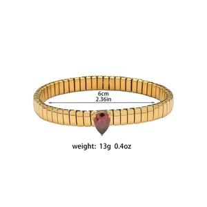 Dettaglio del bracciale elastico dorato con zircone a goccia rossa e diametro di 6cm