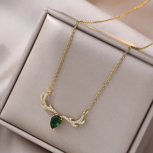 Golden reindeer necklace with a green pear-shaped gemstone and crystal accents