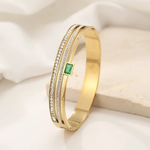 Three-layer gold open bangle with micro-paved crystals and emerald green gemstone