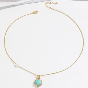 Golden necklace with turquoise stone, white crystal halo and pearls on a fine chain