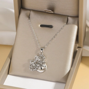 Detailaufnahme der silbernen Halskette mit filigranem Anhänger und Zirkonia-Schleife in Box