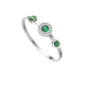 Macro shot of silver bangle with green glass center stone and zircon pavé detail