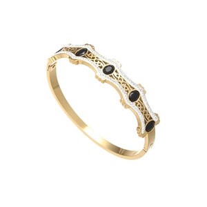 Detalle de brazalete retro dorado con piedras negras ovaladas y micro-pavé de cristales