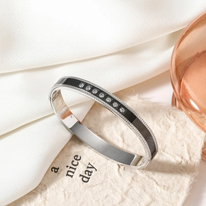 Polished silver stainless steel bangle with black enamel inlay and seven zircon stones