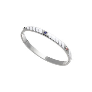 Detailed macro view of silver titanium bangle with colorful zircon gems and white enamel
