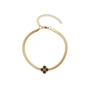 Detail view of gold snake chain bracelet featuring a black clover charm and lobster clasp