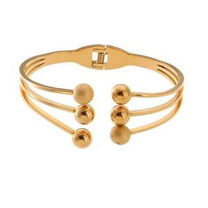 Detail of multi-layer gold plated spring bangle with polished and frosted beads
