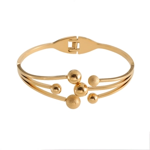 Detail of gold-plated stainless steel spring cuff with polished and frosted beads