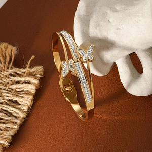 Close-up of golden stainless steel butterfly bangle with sparkling rhinestone inlay