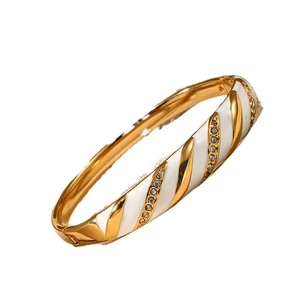 Bracciale rigido in acciaio dorato con design a spirale in smalto bianco e cristalli