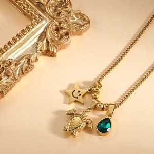 Collier tortue doré avec gemme verte en goutte et pendentif étoile souriante