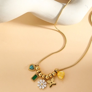 Detail der goldenen Schlangenkette mit Türkisherz und grünem Edelstein-Anhänger