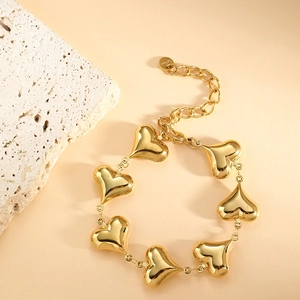 Detailed close-up of golden stainless steel heart charms and adjustable tail chain