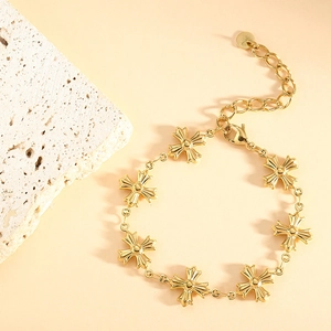 Detailed shot of golden stainless steel bracelet with seven cross-shaped charms and clasp